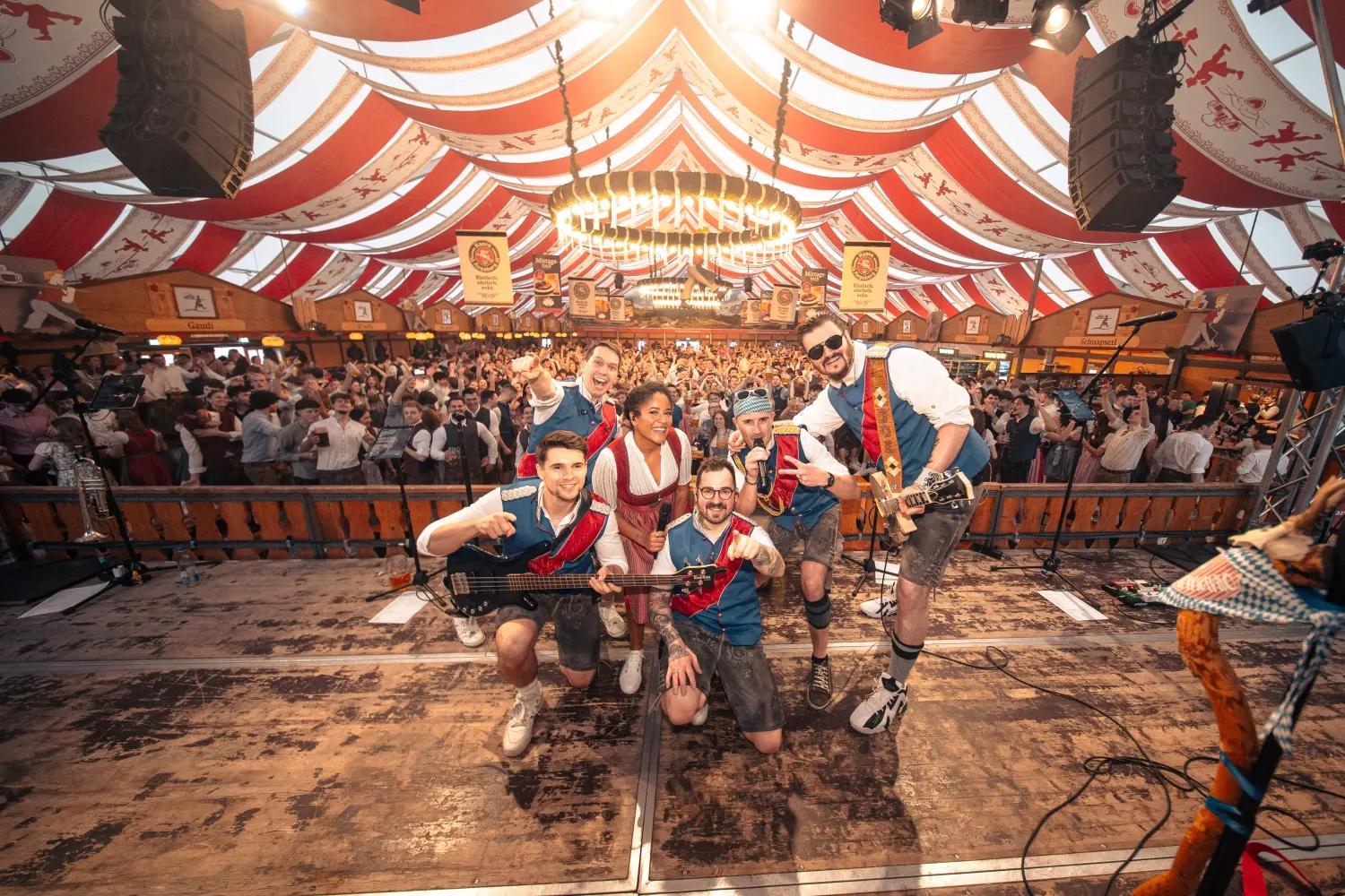 Die Band spielt vor einem vollen Festzelt im Bühnenlicht